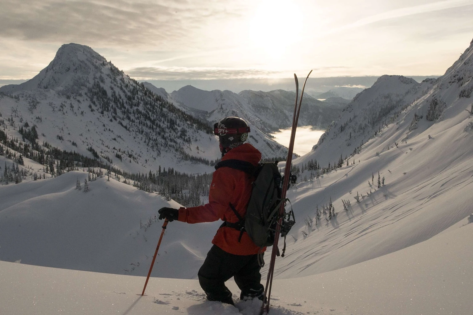 A skier pauses above the vast snow-covered Cedar Valley at Island Lake
