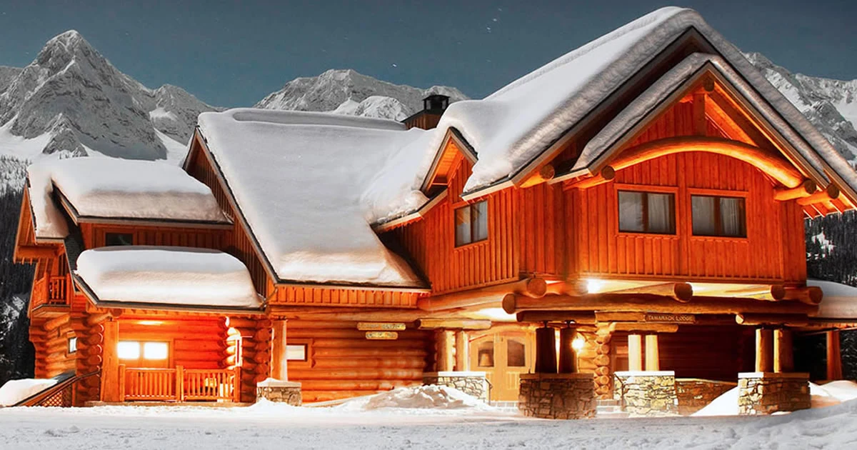 Tamarack Lodge lit up beneath the snowy mountains