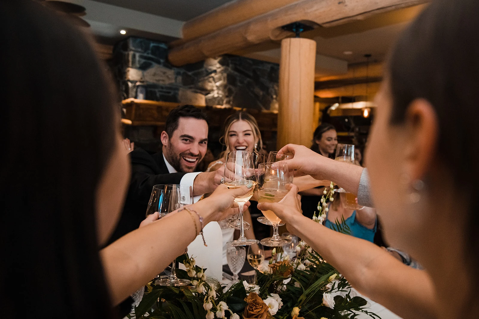 A wedding couple toasting with friends at their reception