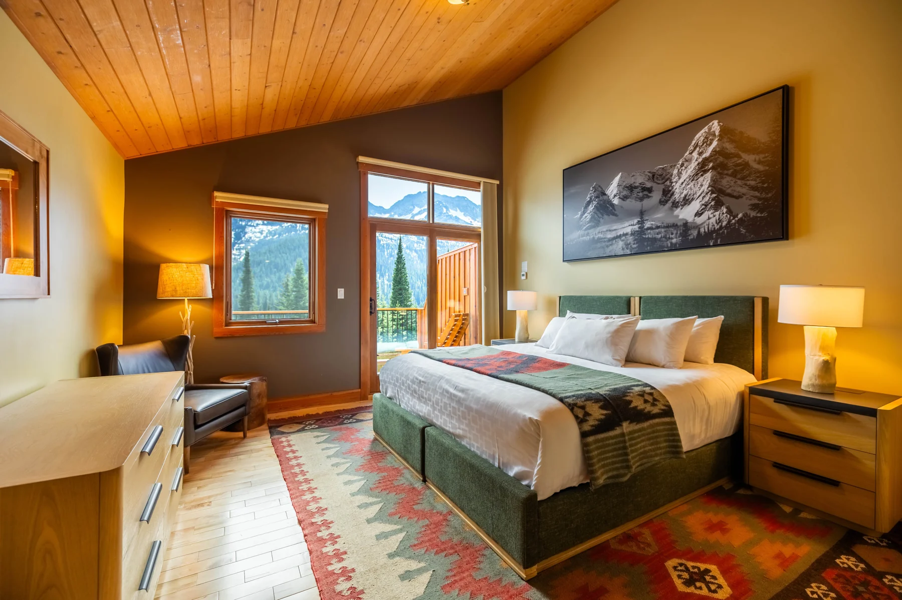 A warm timber guest room with mountain views